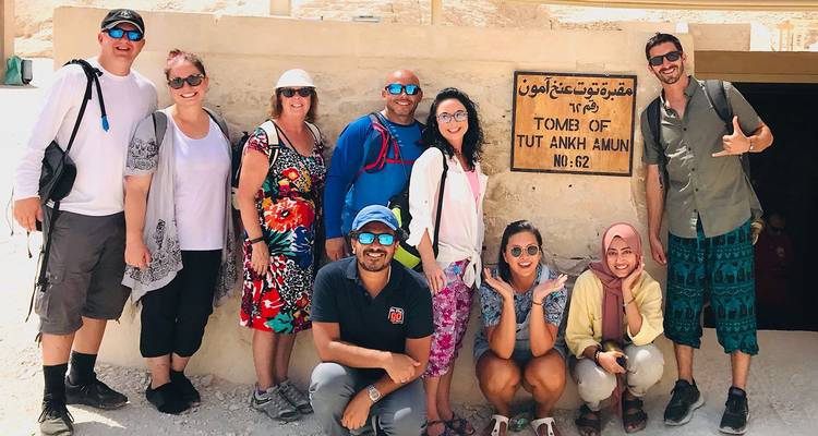 Le groupe de touristes pose devant le panneau d'entrée du tombeau de Toutânkhamon dans la Vallée des Rois.