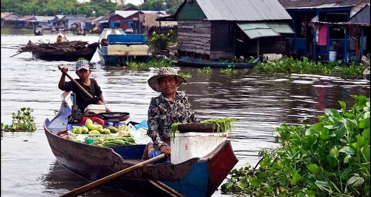 Frauen in einem Holzboot verkaufen Waren auf einem Fluss.