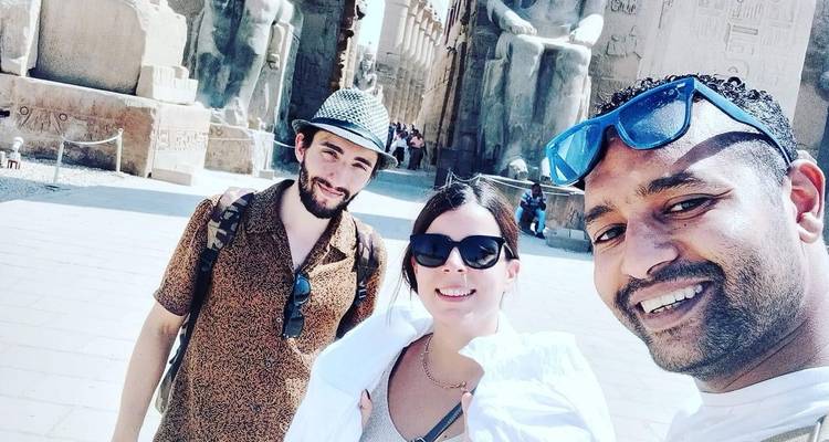 Selfie de tres personas con estatuas del antiguo Egipto de fondo.