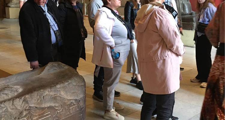 Group of tourists looking inside a museum or monument interior.