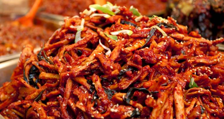 Gros plan d'un plat coréen épicé avec légumes et sauce.