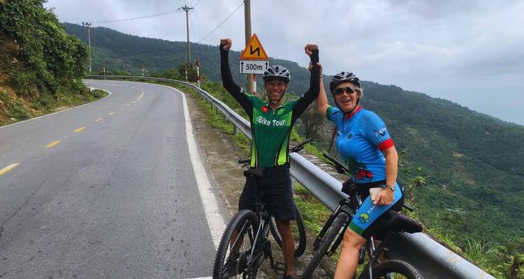 Twee wielrenners die feest vieren op een bergweg.