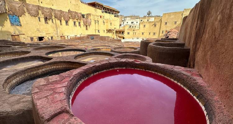 Eine Gerberei mit großen Färbebottichen voller farbiger Flüssigkeiten.