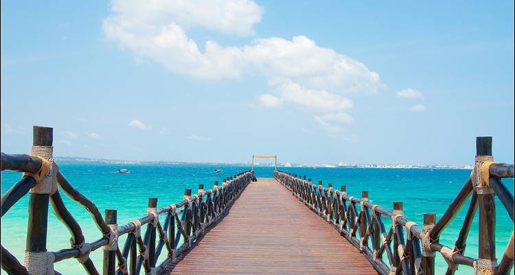 Wooden pier extending into a bright blue ocean.