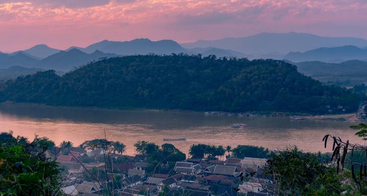Atardecer en tonos pastel suave sobre el río Mekong y las colinas boscosas que rodean Luang Prabang.