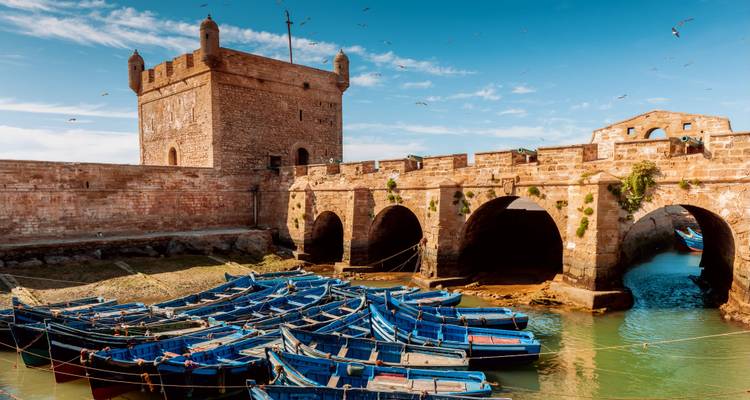 Historisch stenen fort met blauwe boten op de voorgrond.