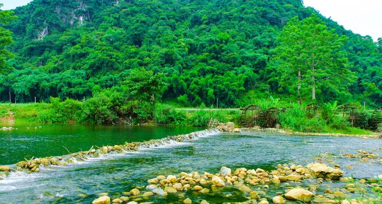 Rivierlandschap met rotsachtige oevers and weelderige groene heuvels.