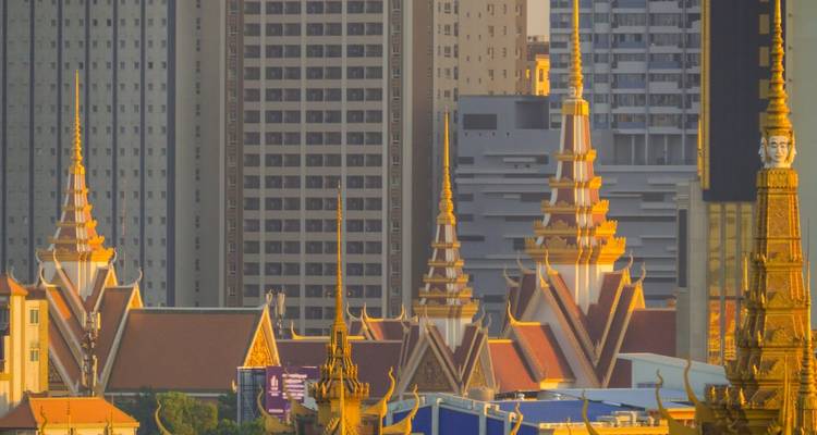 Stadsgezicht met moderne gebouwen en traditionele structuren bij zonsopgang.