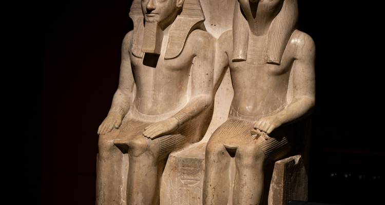 Deux statues de figures égyptiennes antiques assises.