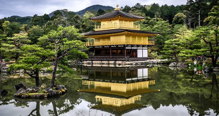 Goldener Tempel spiegelt sich in einem von Bäumen umgebenen Teich wider