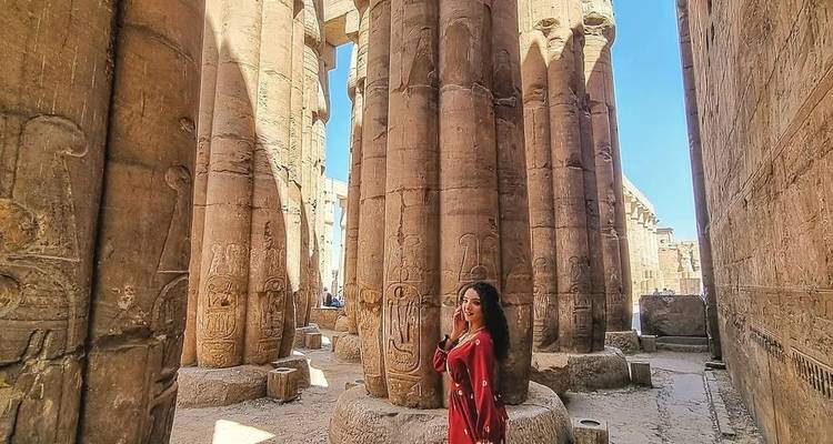 Individual exploring an ancient Egyptian temple with towering columns.