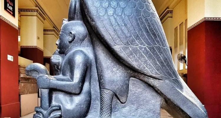 Ancient Egyptian statue in a museum environment.