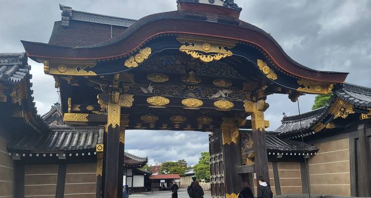 Verziertes Holztor mit Goldverzierungen an einer historischen Stätte.