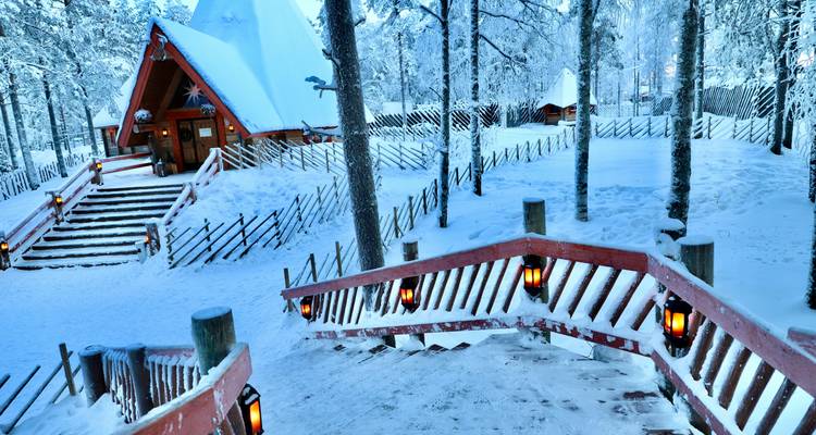 Schneebedeckte Blockhütte in einem Winterwald in Rovaniemi, Finnland.