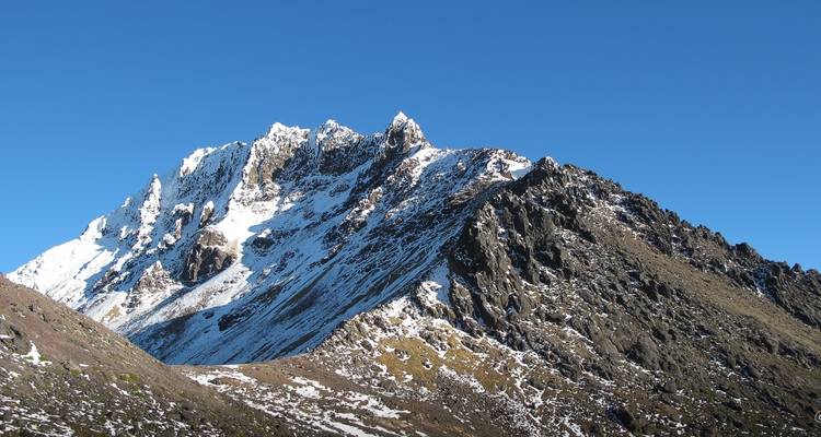 Schneebedeckter Berggipfel unter klarem Himmel.