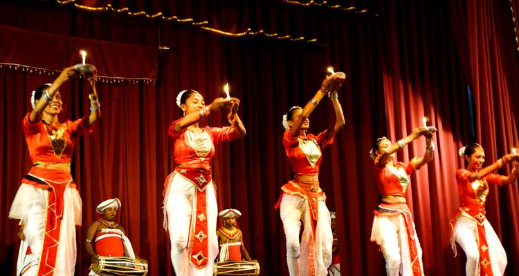 Traditionele dansers die optreden op het podium met kaarsen.