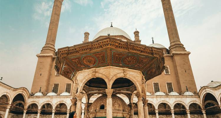 Entrée d'une mosquée ornée avec de grands dômes.