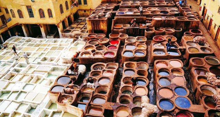 Traditional tannery with several colorful dyeing pits in an open area.