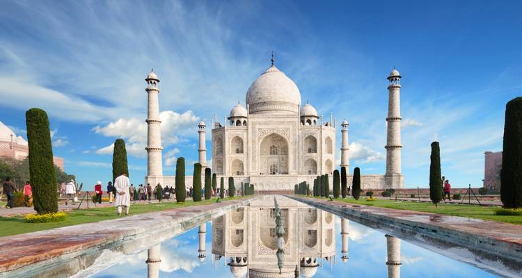 Taj Mahal met zijn reflecterende vijver onder een heldere blauwe hemel.