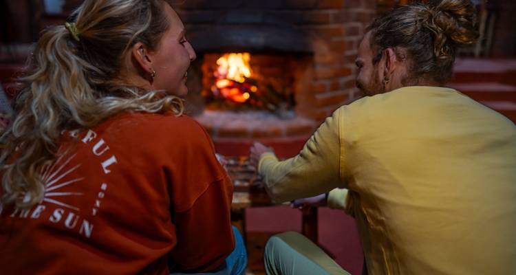 Zwei Personen, die am Kamin sitzen und sich unterhalten.