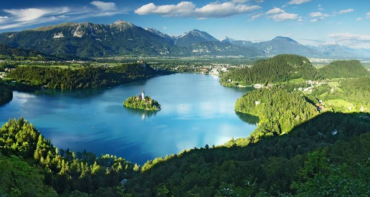 Ein malerischer See, umgeben von Bergen, mit einer Insel in der Mitte.