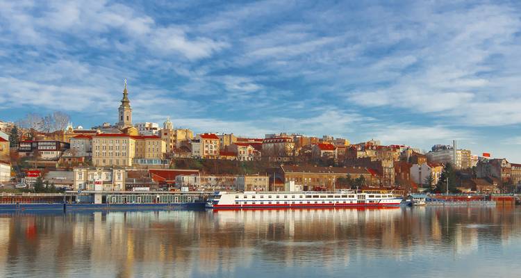 Cityscape by a river with historic buildings.