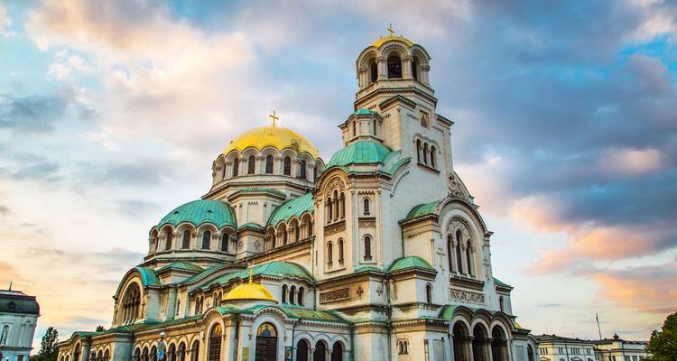 Die vergoldeten Kuppeln der Alexander-Newski-Kathedrale, die unter pastellfarbenen Wolken einer Morgenröte in Sofia erglänzen.