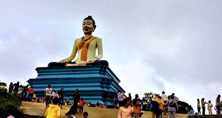 Eine große Buddha-Statue mit Menschen drumherum.