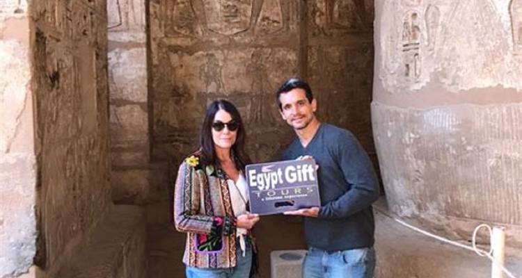 Couple posing with a tour sign in an Egyptian site.