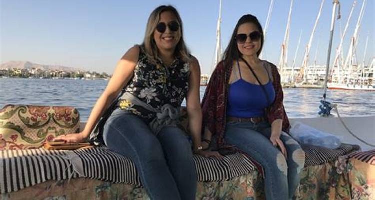 Twee vrouwen zittend op een boot met de Nijl op de achtergrond.