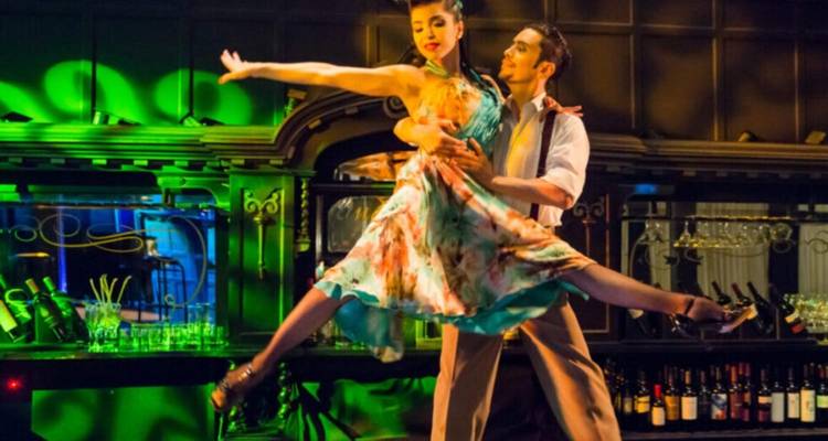 Paar, das einen Tango auf der Bühne mit bunten Lichtern tanzt.