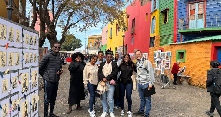 Gruppe von Menschen, die vor bunten Gebäuden posiert.