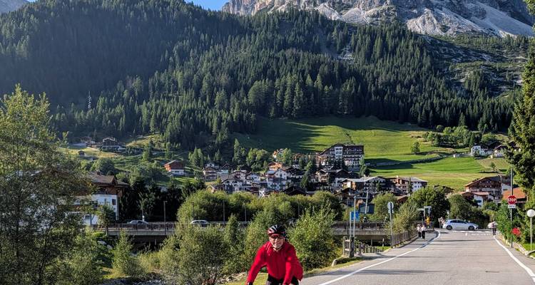 Cycliste sur une route pittoresque avec paysage alpin.