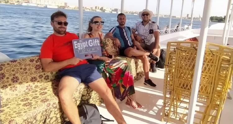 Groupe de personnes sur un bateau tenant une pancarte avec 'Egypt Gift Tours'.