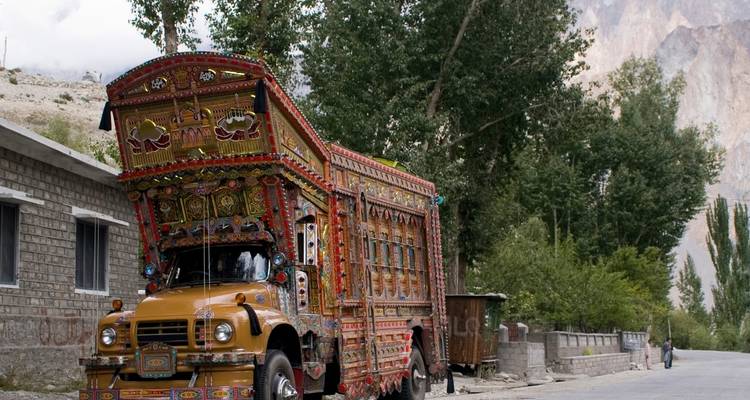 Hochdekorierter LKW, der auf einer von Grün umgebenen Straße geparkt ist.