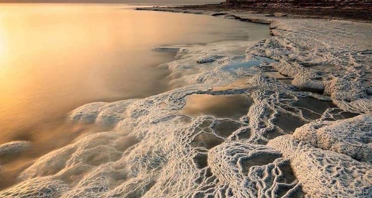 Zoutformaties langs de kust van de Dode Zee met gouden tinten.