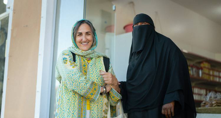 Deux femmes se saluant à l'extérieur.