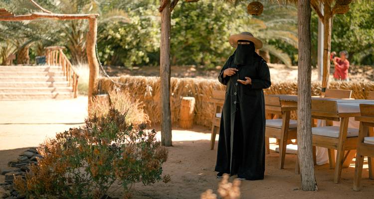 Femme portant une tenue traditionnelle marchant à l'extérieur.