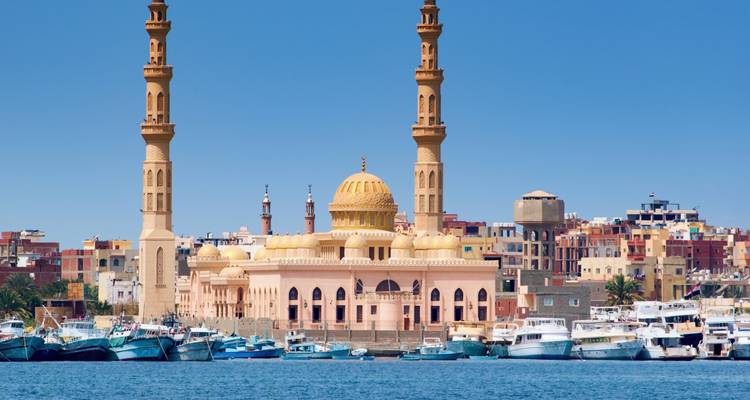 Prachtige moskee met twee minaretten aan het water met afgemeerde boten.