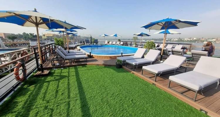 Deck eines Kreuzfahrtschiffs mit einem Schwimmbad und Liegestühlen unter Sonnenschirmen.