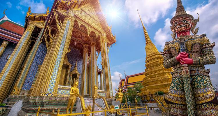 Tempelcomplex met gigantische wachterbeelden en gouden pagodes.