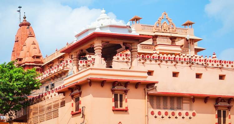 Edificios de templos ornamentados y coloridos con cúpulas, agujas e intrincadas tallas contra un cielo azul brillante.