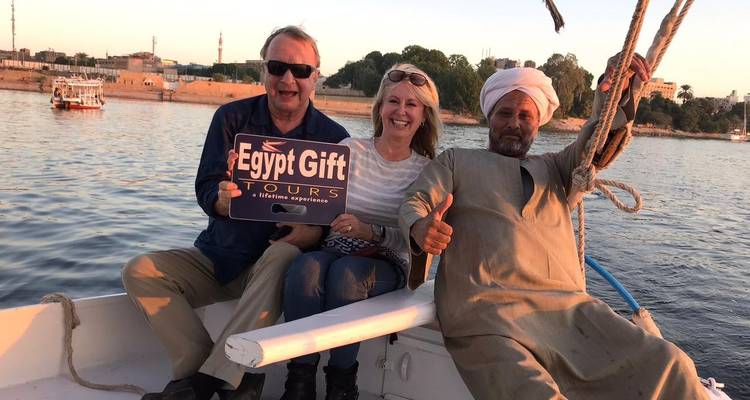 Pareja sentada en un barco con un letrero de Egypt Gift Tours.
