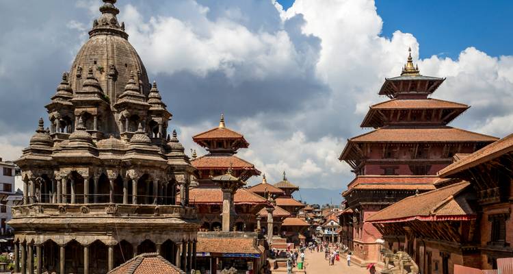 Menschen die door Patan Durbar Square lopen met traditionele bakstenen architectuur.