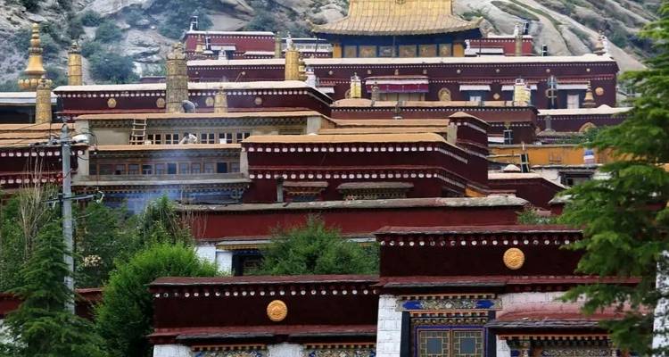 Eine Reihe von Gebäuden mit goldenen Dächern in einer hügeligen Gegend.