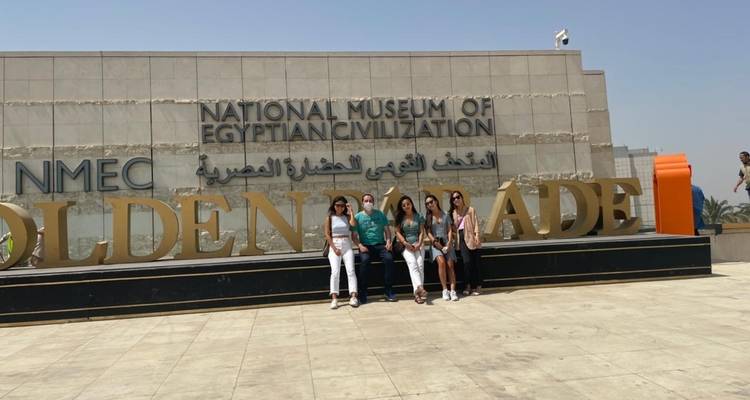 Groupe de personnes posant devant l'entrée d'un musée.