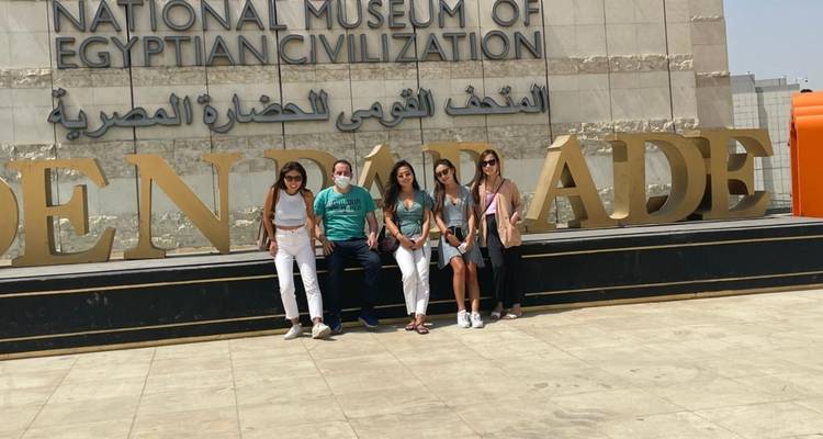 Groupe posant à l'entrée du musée avec un panneau.