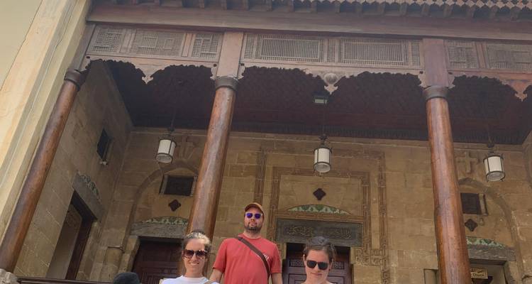 Menschen stehen vor einem Gebäude mit Holzbalken.