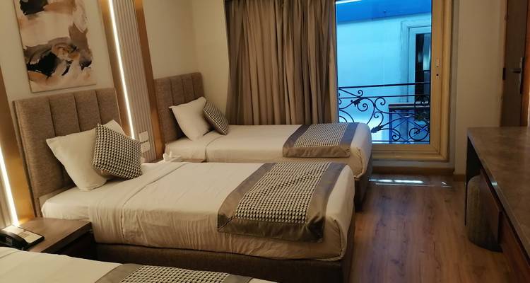 Hotelzimmer mit zwei Einzelbetten und Balkon mit Aussicht.