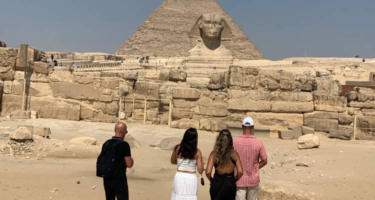 Group standing with backs to camera gazing at the Sphinx and Khafre Pyramid.